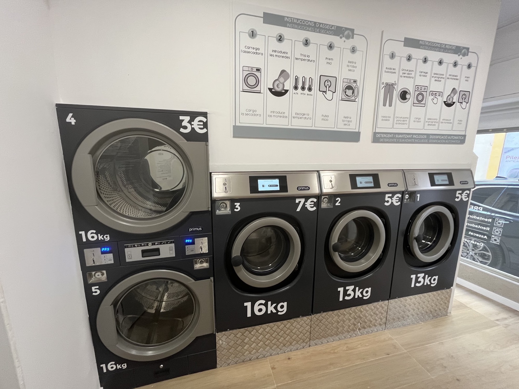 Interior lluminós d’una bugaderia amb rentadores